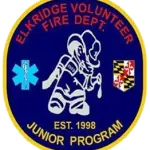 A circular blue emblem with a yellow border. Text reads "Elkridge Volunteer Fire Dept. Junior Program, Est. 1998." Features a cartoon firefighter, EMS symbol, and Maryland state flag.